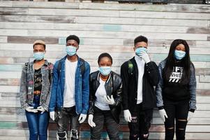 gruppo di amici adolescenti africani che indossano maschere mediche proteggono da infezioni e malattie quarantena del virus del coronavirus. foto