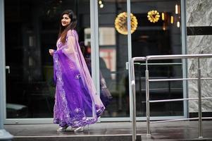 ragazza indù indiana al tradizionale saree viola poste in strada. foto