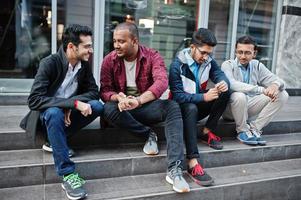 gruppo di quattro studenti maschi adolescenti indiani. i compagni di classe trascorrono del tempo insieme. foto