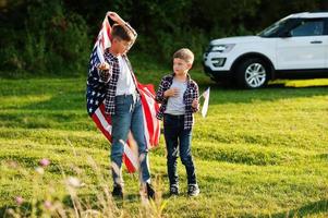 due fratelli con bandiera usa. vacanza in america. orgogliosi di essere figli di campagna. foto