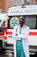 paramedico maschio africano in piedi davanti all'auto dell'ambulanza. foto