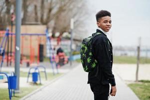 giovane ragazzo africano millenario che cammina in città. uomo di colore felice con lo zaino di marijuana. concetto di generazione z. foto