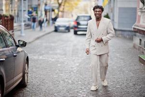 elegante uomo afro in abito beige vecchia scuola. giovane maschio africano alla moda in giacca casual sul torso nudo. foto