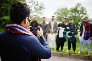 gruppo di pakistani che indossano abiti tradizionali salwar kameez o kurta con bandiere pakistane. foto