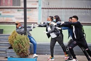 gruppo di amici adolescenti africani al parco che indossano maschere mediche proteggono da infezioni e malattie quarantena del virus del coronavirus. foto