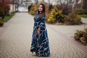 bruna donna indiana in abito lungo alla moda poste all'aperto. foto