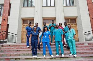 gruppo di studenti di medicina africani posati all'aperto contro la porta dell'università. foto