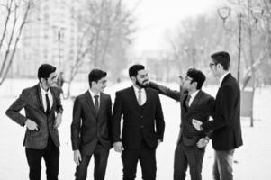 un gruppo di cinque uomini d'affari indiani in giacca e cravatta hanno posato all'aperto e hanno condotto una discussione nella giornata invernale in Europa. foto