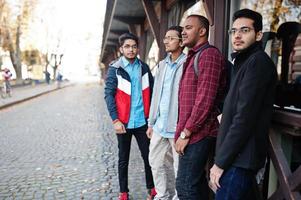 gruppo di quattro studenti maschi adolescenti indiani. i compagni di classe trascorrono del tempo insieme. foto