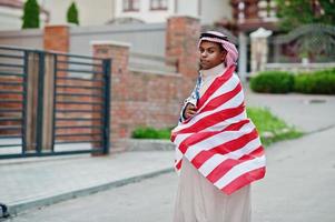 uomo arabo mediorientale posato su strada con bandiera usa. concetto di america e paesi arabi. foto