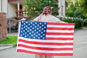 uomo arabo mediorientale posato su strada con bandiera usa. concetto di america e paesi arabi. foto