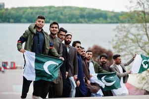 gruppo di pakistani che indossano abiti tradizionali salwar kameez o kurta con bandiere pakistane. foto