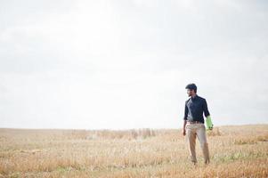 agronomo agricoltore del sud asiatico che ispeziona l'azienda agricola del campo di grano. concetto di produzione agricola. foto