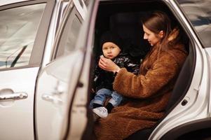 giovane madre e bambino in auto. concetto di guida di sicurezza. foto