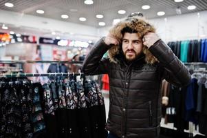 elegante uomo turco al negozio di pellicce e giacche di pelle. uomo di successo con la barba araba. foto