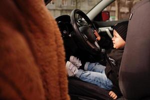 giovane madre e bambino in auto. concetto di guida di sicurezza. foto