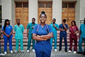 gruppo di studenti di medicina africani posati all'aperto contro la porta dell'università. foto