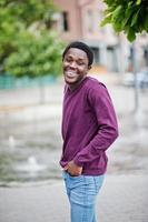 giovane uomo afroamericano in maglione viola posato contro il vicolo della fontana. foto
