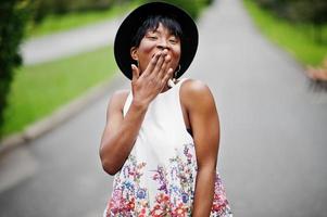 incredibile modella afroamericana in pantaloni verdi e cappello nero in posa con diverse emozioni al parco, mostra una faccia a sorpresa. foto