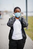 ragazza africana al parco che indossa maschere mediche protegge da infezioni e malattie quarantena del virus del coronavirus. foto