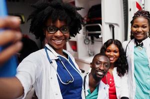 gruppo di medici africani dell'equipaggio di emergenza dell'ambulanza paramedica che fanno selfie sul telefono. foto