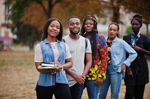 fila di studenti universitari africani del gruppo cinque che trascorrono del tempo insieme nel campus nel cortile dell'università. amici afro neri che studiano. tema dell'educazione. foto