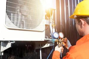 un tecnico professionista del condizionatore d'aria che controlla il refrigerante. foto