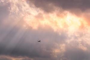 aereo che vola attraverso raggi di sole foto