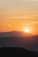 paesaggio al tramonto con illuminazione dorata di montagna e sole sotto il vivace cielo serale colorato in montagna. natura montagna cielo e nuvole tramonto concetto foto