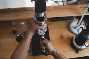 caffè barista che prepara il caffè con il concetto di servizio di preparazione della macchina per caffè espresso a leva manuale nel ristorante. primo piano barista a mano che prepara caffè fresco con macchina da caffè nella caffetteria. fare il caffè fresco. foto