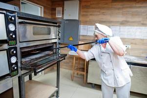 chef femminile che prepara pizza nella cucina del ristorante. foto