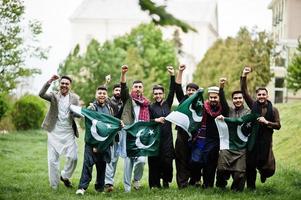 gruppo di pakistani che indossano abiti tradizionali salwar kameez o kurta con bandiere pakistane. foto