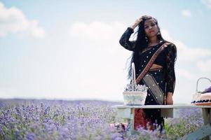 bella ragazza indiana indossa un abito tradizionale saree india nel campo di lavanda viola. foto