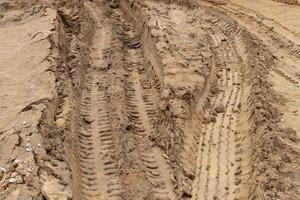 strada davanti fango liquido fuori strada e ci sono segni di pneumatici. foto