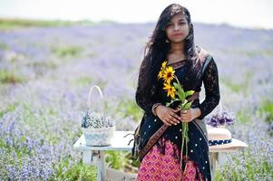 bella ragazza indiana indossa un abito tradizionale saree india nel campo di lavanda viola. foto
