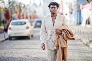 elegante uomo afro in abito beige vecchia scuola. giovane maschio africano alla moda in giacca casual sul torso nudo. foto