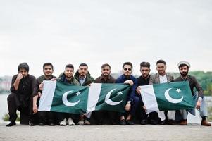 gruppo di pakistani che indossano abiti tradizionali salwar kameez o kurta con bandiere pakistane. foto