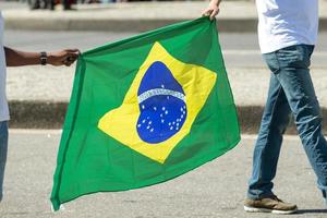 due persone che tengono la bandiera brasiliana foto