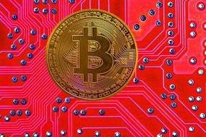 bitcoin singolo di valore dorato da criptovaluta con un bordo rosso chiaro nella parte posteriore foto