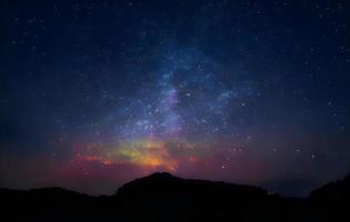 paesaggio notturno con colorata Via Lattea e montagne. cielo stellato con colline in estate. bellissimo universo. sfondo dello spazio foto