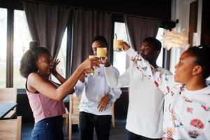 felici amici africani seduti e chiacchierando nella caffetteria. gruppo di persone di colore che si incontrano e applausi nel ristorante. foto