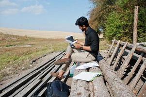 agronomo agricoltore del sud asiatico guardando i documenti del diagramma in fattoria. concetto di produzione agricola. foto