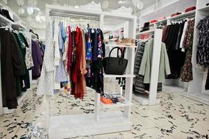 set di abbigliamento femminile colorato sugli scaffali nella nuovissima boutique moderna del negozio di abbigliamento. foto