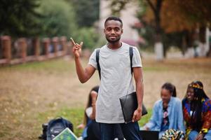 gruppo di cinque studenti universitari africani che trascorrono del tempo insieme nel campus nel cortile dell'università. amici afro neri che studiano. tema dell'educazione. foto