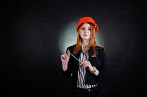 ingegnere donna in arancione protegge il casco con pensil. foto