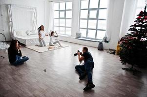 il team di due fotografi che riprende le gemelle in studio che stanno mangiando la pizza. fotografo professionista al lavoro. foto