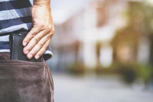 uomo sicuro di sé in posa al sicuro tenendo il portafoglio nella tasca posteriore dei pantaloni della tasca posteriore. risparmio denaro finanza. foto