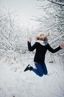 ragazza bionda che si diverte con la neve al giorno d'inverno. foto