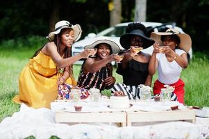 gruppo di ragazze afroamericane che celebrano la festa di compleanno e bicchieri tintinnanti all'aperto con decorazioni. foto