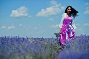 bella ragazza indiana indossa un abito tradizionale saree india nel campo di lavanda viola. foto